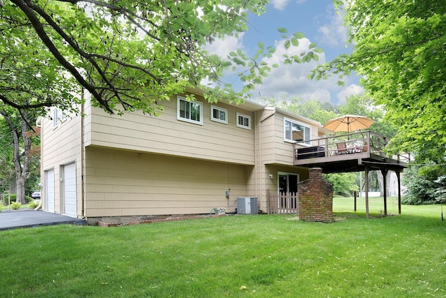 11 Claremont Ln, Suffern, NY 10901 - rear view of property featuring an attached garage, a lawn, a wooden deck, and driveway