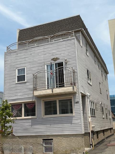 148 Bch 97th St, Rockaway Beach, NY 11693 - back of property featuring a balcony and a shingled roof