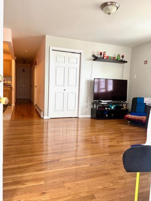 148 Bch 97th St, Rockaway Beach, NY 11693 - living room featuring a baseboard heating unit and light wood finished floors