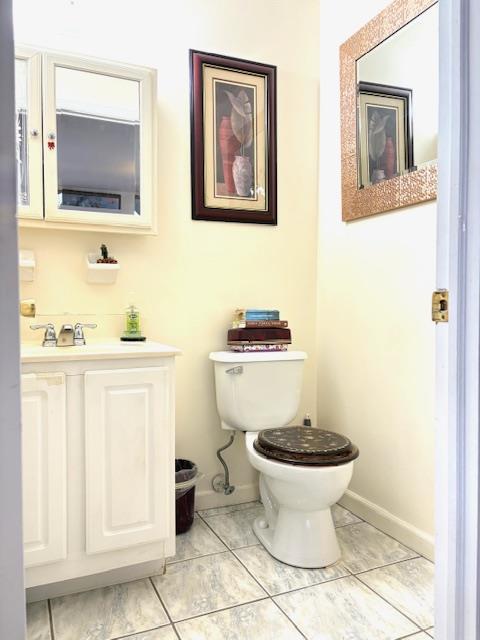 148 Bch 97th St, Rockaway Beach, NY 11693 - bathroom featuring toilet, baseboards, and vanity
