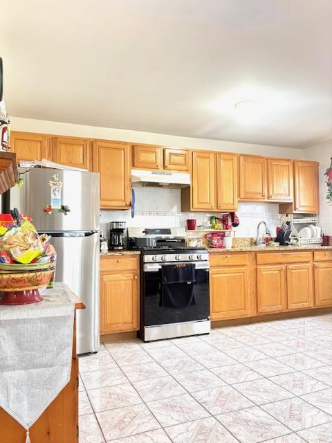 148 Bch 97th St, Rockaway Beach, NY 11693 - kitchen with stainless steel appliances, under cabinet range hood, a sink, and backsplash