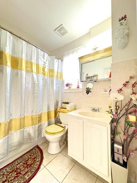 148 Bch 97th St, Rockaway Beach, NY 11693 - full bathroom with tile patterned floors, toilet, vanity, and curtained shower