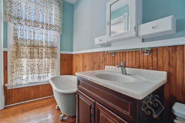 25 Garfield Pl, Poughkeepsie, NY 12601 - bathroom featuring a freestanding bath, vanity, wainscoting, wood finished floors, and toilet