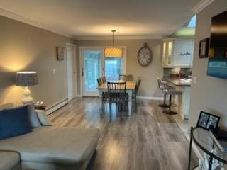 738 Craft Ave, Franklin Square, NY 11010 - living area with wood finished floors, baseboard heating, crown molding, and baseboards