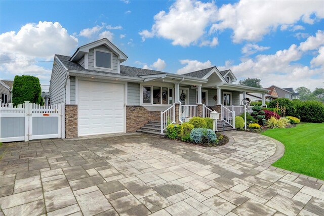 738 Craft Ave, Franklin Square, NY 11010 - view of front of property with stone siding, decorative driveway, covered porch, a shingled roof, and a gate