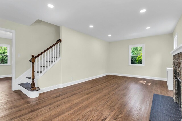 46 Beatrice Ct, Hempstead, NY 11550 - unfurnished living room featuring plenty of natural light, a stone fireplace, wood finished floors, stairs, and recessed lighting