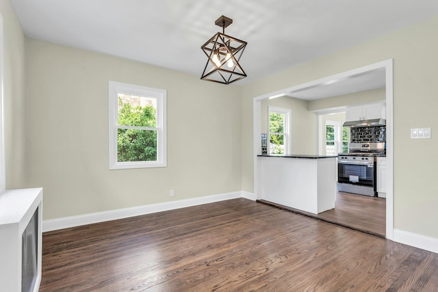 46 Beatrice Ct, Hempstead, NY 11550 - unfurnished dining area featuring plenty of natural light, dark wood-style floors, baseboards, and a chandelier