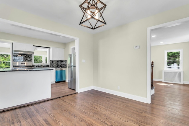 46 Beatrice Ct, Hempstead, NY 11550 - unfurnished dining area featuring dark wood-type flooring, a sink, healthy amount of natural light, baseboards, and recessed lighting