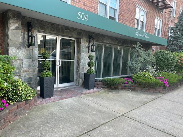 504 Merrick Rd Unit 4E, Lynbrook, NY 11563 - property entrance with stone siding and brick siding