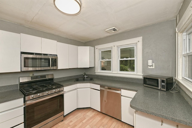 426 Lakeview Rd, Bellmore, NY 11710 - kitchen with appliances with stainless steel finishes, a sink, dark countertops, and white cabinets