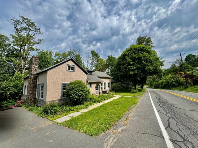 13 Rockland Rd, Roscoe, NY 12776 - view of property exterior featuring a chimney, stone siding, and stucco siding