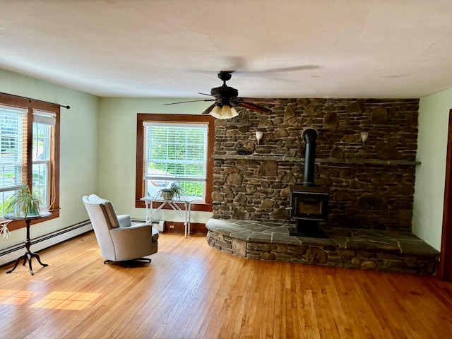13 Rockland Rd, Roscoe, NY 12776 - living area with wood finished floors, ceiling fan, a wood stove, and baseboard heating