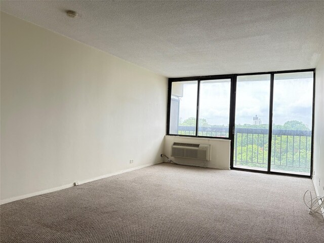 152-18 Union Tpke Unit 9P, Flushing, NY 11367 - carpeted empty room with a smoke detector, a wall mounted AC, baseboards, and a textured ceiling