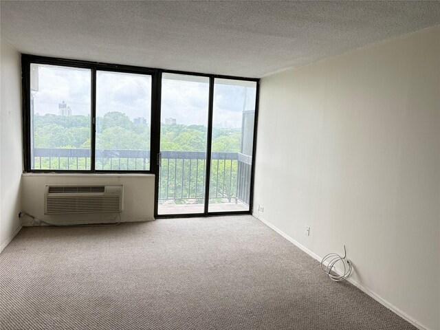 152-18 Union Tpke Unit 9P, Flushing, NY 11367 - spare room featuring carpet floors, a wall mounted air conditioner, a textured ceiling, and baseboards