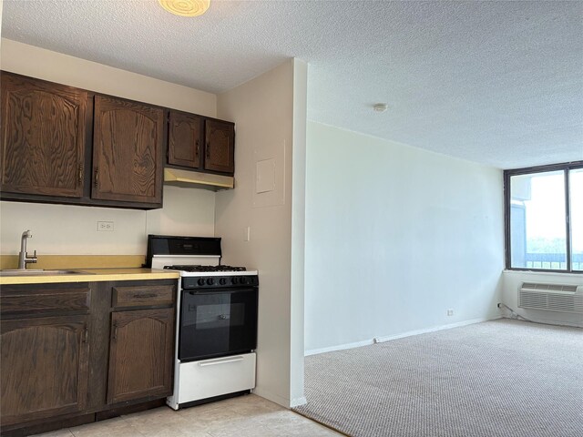 152-18 Union Tpke Unit 9P, Flushing, NY 11367 - kitchen with range with gas cooktop, dark brown cabinets, a sink, a textured ceiling, and light countertops