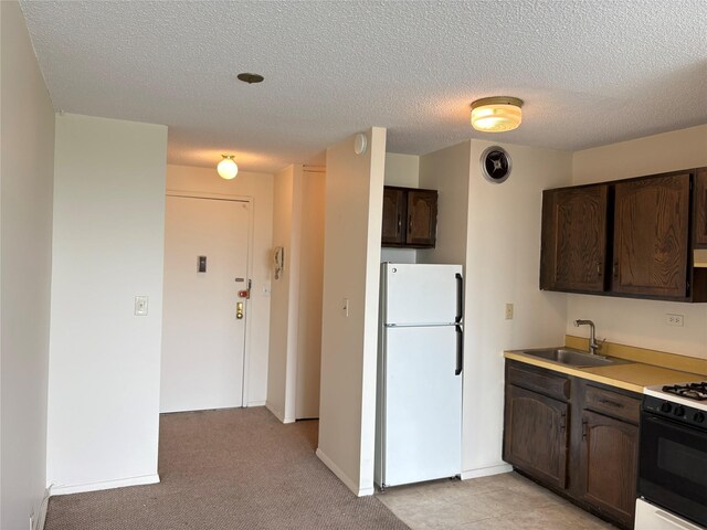 152-18 Union Tpke Unit 9P, Flushing, NY 11367 - kitchen featuring freestanding refrigerator, a sink, dark brown cabinetry, gas range, and a textured ceiling