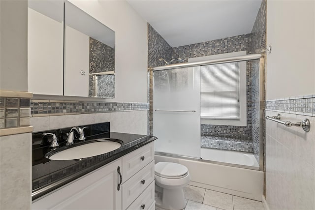 81 Hidden Ridge Dr, Syosset, NY 11791 - full bathroom featuring tile walls, tile patterned flooring, vanity, and bath / shower combo with glass door