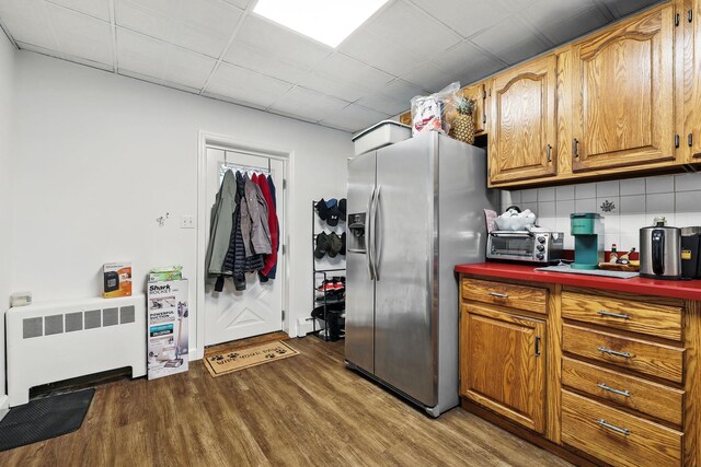 305 Columbus Ave, Harrison, NY 10604 - kitchen featuring stainless steel fridge, radiator heating unit, dark wood-style floors, decorative backsplash, and dark countertops