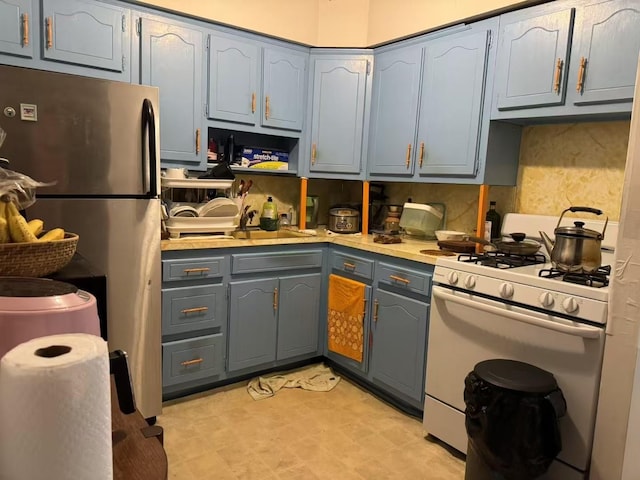 40-18 165th St, Flushing, NY 11358 - kitchen featuring white gas range oven, freestanding refrigerator, gray cabinetry, and light countertops