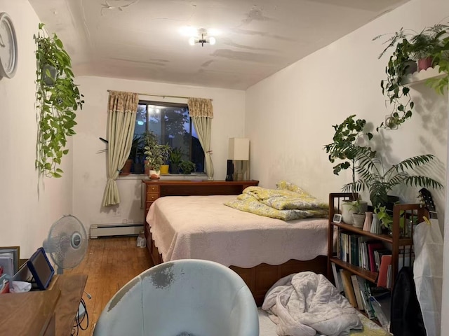 40-18 165th St, Flushing, NY 11358 - bedroom with wood finished floors and a baseboard radiator