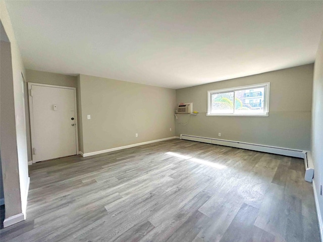 1548 Rte 9 Unit 1A, Wappingers Falls, NY 12590 - unfurnished room with a baseboard radiator, wood finished floors, baseboards, and a wall mounted air conditioner