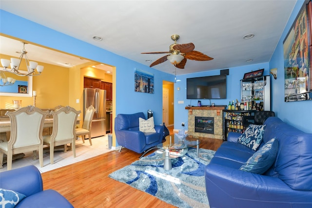 1319 E 86th St, Brooklyn, NY 11236 - living room featuring a ceiling fan, a chandelier, light wood-style flooring, and a tile fireplace