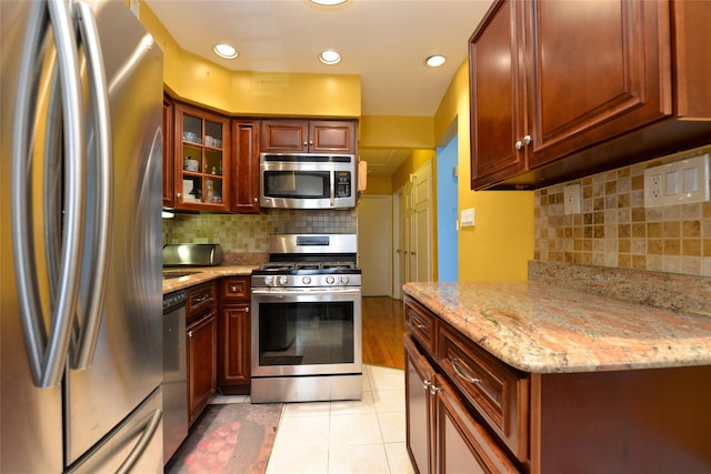 1319 E 86th St, Brooklyn, NY 11236 - kitchen featuring appliances with stainless steel finishes, backsplash, light stone countertops, light tile patterned flooring, and recessed lighting