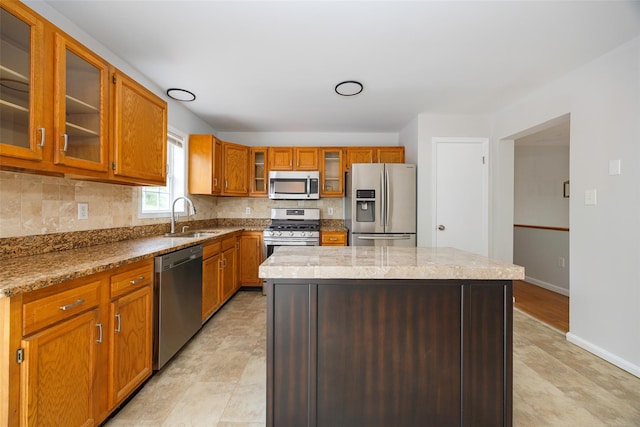 15 Pond St, Poughkeepsie, NY 12603 - kitchen featuring stainless steel appliances, a sink, tasteful backsplash, brown cabinets, and glass insert cabinets