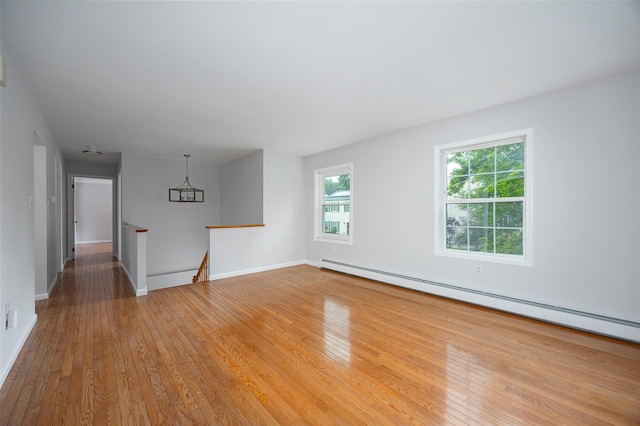 15 Pond St, Poughkeepsie, NY 12603 - spare room featuring wood-type flooring, a baseboard heating unit, baseboards, and a chandelier