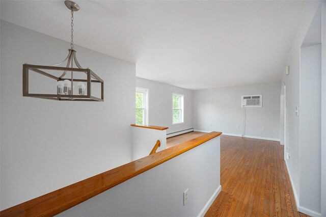 15 Pond St, Poughkeepsie, NY 12603 - hallway featuring baseboard heating, an AC wall unit, wood-type flooring, and baseboards