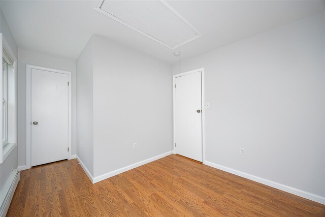 15 Pond St, Poughkeepsie, NY 12603 - unfurnished room featuring attic access, baseboard heating, light wood-style flooring, and baseboards