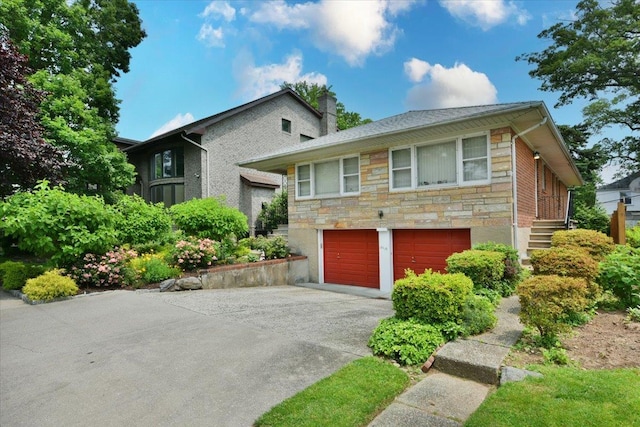8519 212th St, Hollis Hills, NY 11427 - view of front of home featuring concrete driveway, a garage, stone siding, and a chimney