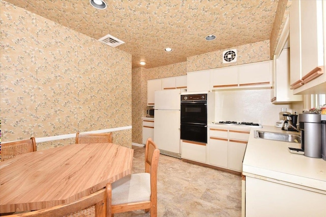 8519 212th St, Hollis Hills, NY 11427 - kitchen featuring black oven, freestanding refrigerator, light countertops, recessed lighting, and wallpapered walls