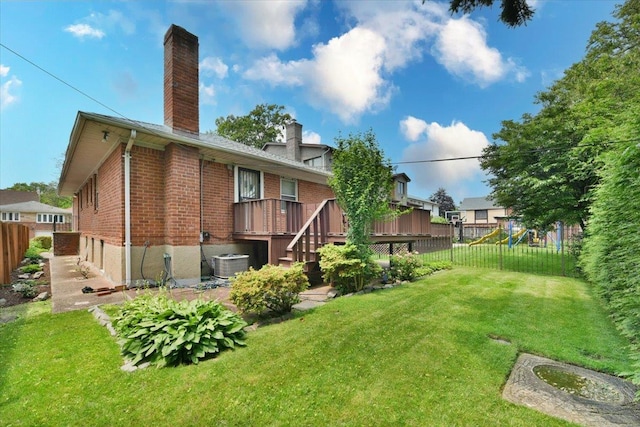 8519 212th St, Hollis Hills, NY 11427 - rear view of property with a chimney, a fenced backyard, a wooden deck, brick siding, and a playground
