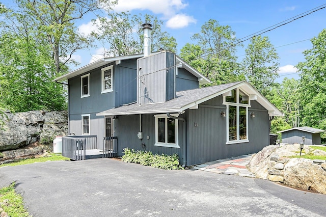 39 Cliff Rd, Greenwood Lake, NY 10925 - view of front of home featuring a shingled roof, a deck, a shed, and a patio area
