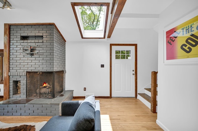 39 Cliff Rd, Greenwood Lake, NY 10925 - living area featuring wood finished floors, a skylight, stairway, lofted ceiling, and a fireplace