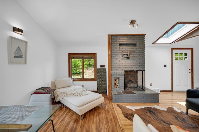 39 Cliff Rd, Greenwood Lake, NY 10925 - living area with lofted ceiling, wood finished floors, a skylight, and a brick fireplace