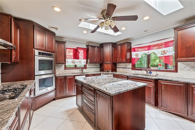 19 Farview Ter, Airmont, NY 10901 - kitchen featuring appliances with stainless steel finishes, a skylight, light tile patterned flooring, decorative backsplash, and recessed lighting