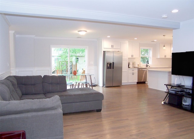 8 W Narcissus Rd, Mastic Beach, NY 11951 - living area with crown molding, dark wood-style floors, a decorative wall, wainscoting, and recessed lighting