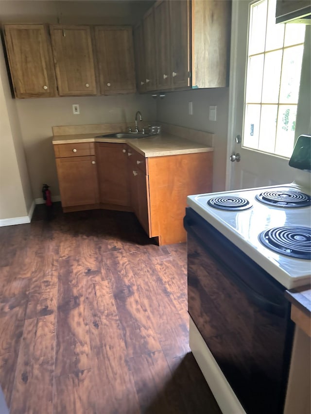 9 Hunt Ln, Levittown, NY 11756 - kitchen with range with electric stovetop, a sink, dark wood-style flooring, light countertops, and brown cabinets