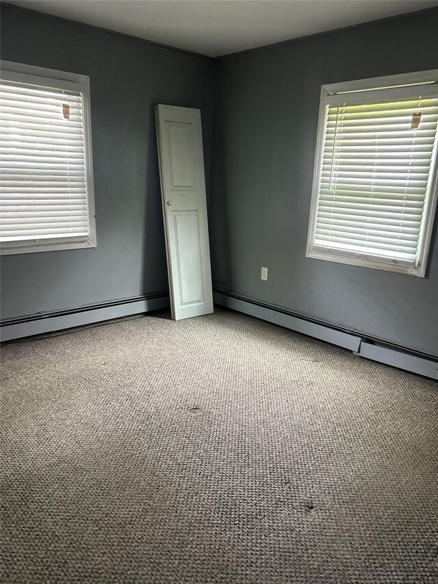 9 Hunt Ln, Levittown, NY 11756 - spare room with a baseboard heating unit, carpet, and plenty of natural light