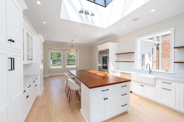 1750 Mount Beulah Ave, Southold, NY 11971 - kitchen with butcher block countertops, high end fridge, open shelves, light wood-type flooring, and a kitchen island