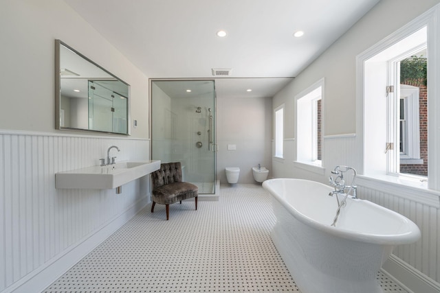 1750 Mount Beulah Ave, Southold, NY 11971 - full bathroom with healthy amount of natural light, a shower stall, a wainscoted wall, recessed lighting, and a soaking tub