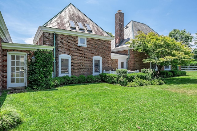 1750 Mount Beulah Ave, Southold, NY 11971 - view of front facade with a high end roof, brick siding, and a chimney