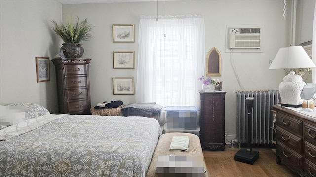 14436 32nd Ave, Flushing, NY 11354 - bedroom with radiator heating unit, a wall mounted air conditioner, and wood finished floors