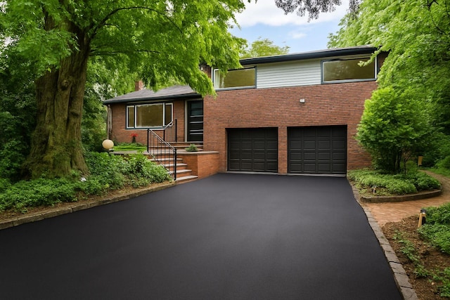 8 Junard Dr, Roslyn, NY 11576 - split level home featuring asphalt driveway, a garage, and brick siding