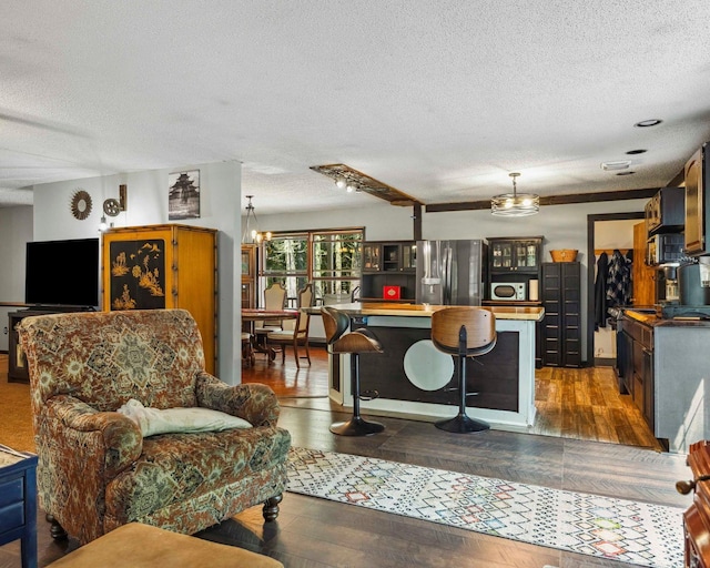 12 Summit Dr, Eldred, NY 12792 - kitchen with stainless steel appliances, a textured ceiling, a center island, dark wood-type flooring, and a breakfast bar area