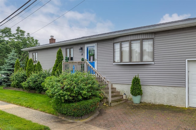 12 Roosevelt Pl, Massapequa, NY 11758 - view of front of house featuring a chimney and a garage