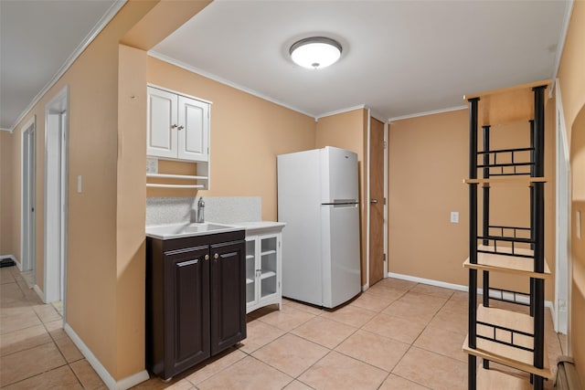12 Roosevelt Pl, Massapequa, NY 11758 - kitchen featuring freestanding refrigerator, a sink, light countertops, light tile patterned flooring, and crown molding