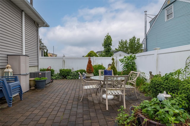 12 Roosevelt Pl, Massapequa, NY 11758 - fenced backyard featuring a patio, cooling unit, and outdoor dining space